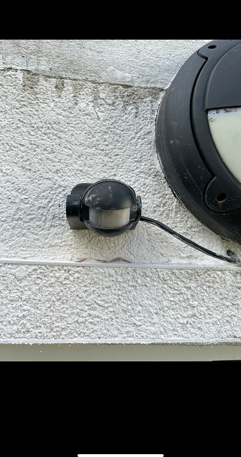 Exterior light fitting and weatherproof junction box on a house wall in Glasgow
