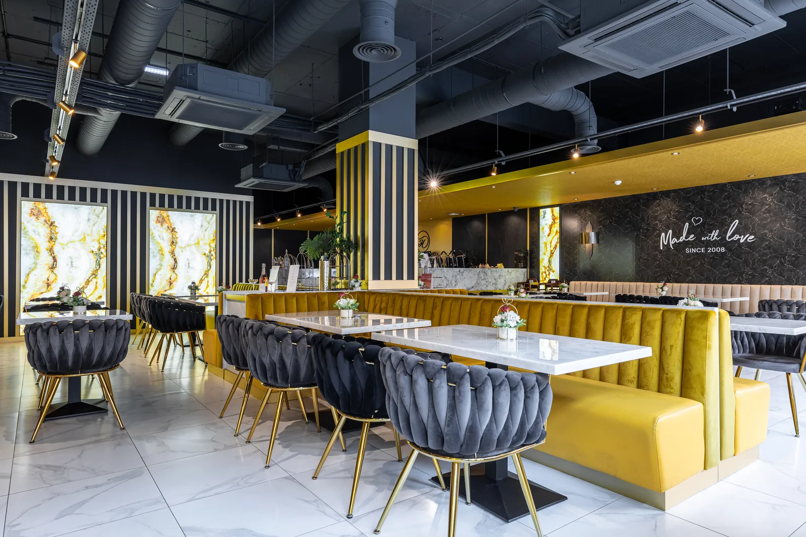 Completed commercial dessert restaurant interior in Glasgow with track lighting, feature pendants and backlit panels wired by MMM Electrical