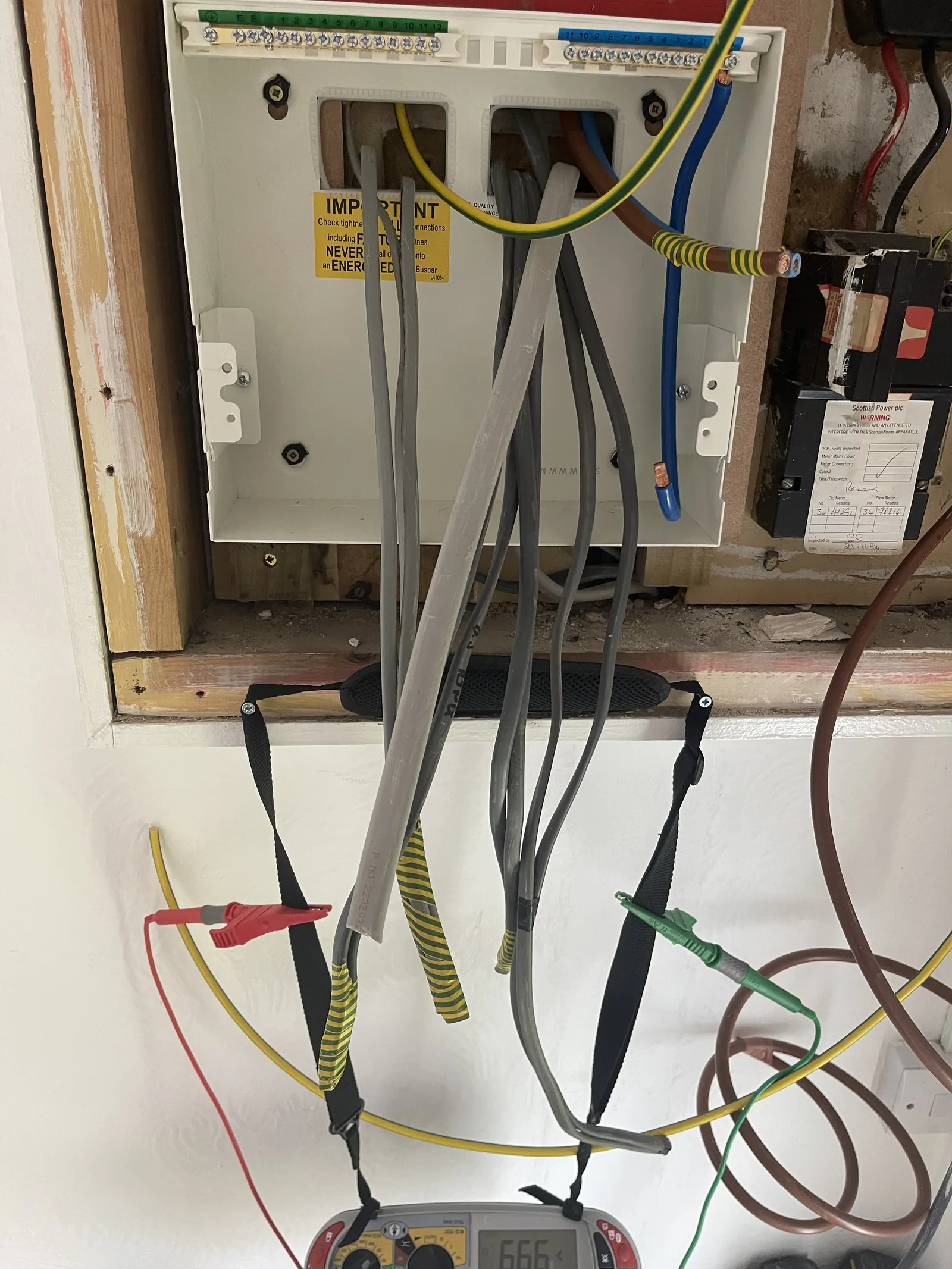 Multifunction tester leads clipped to the earth bar of a consumer unit during electrical testing by MMM Electrical in Glasgow