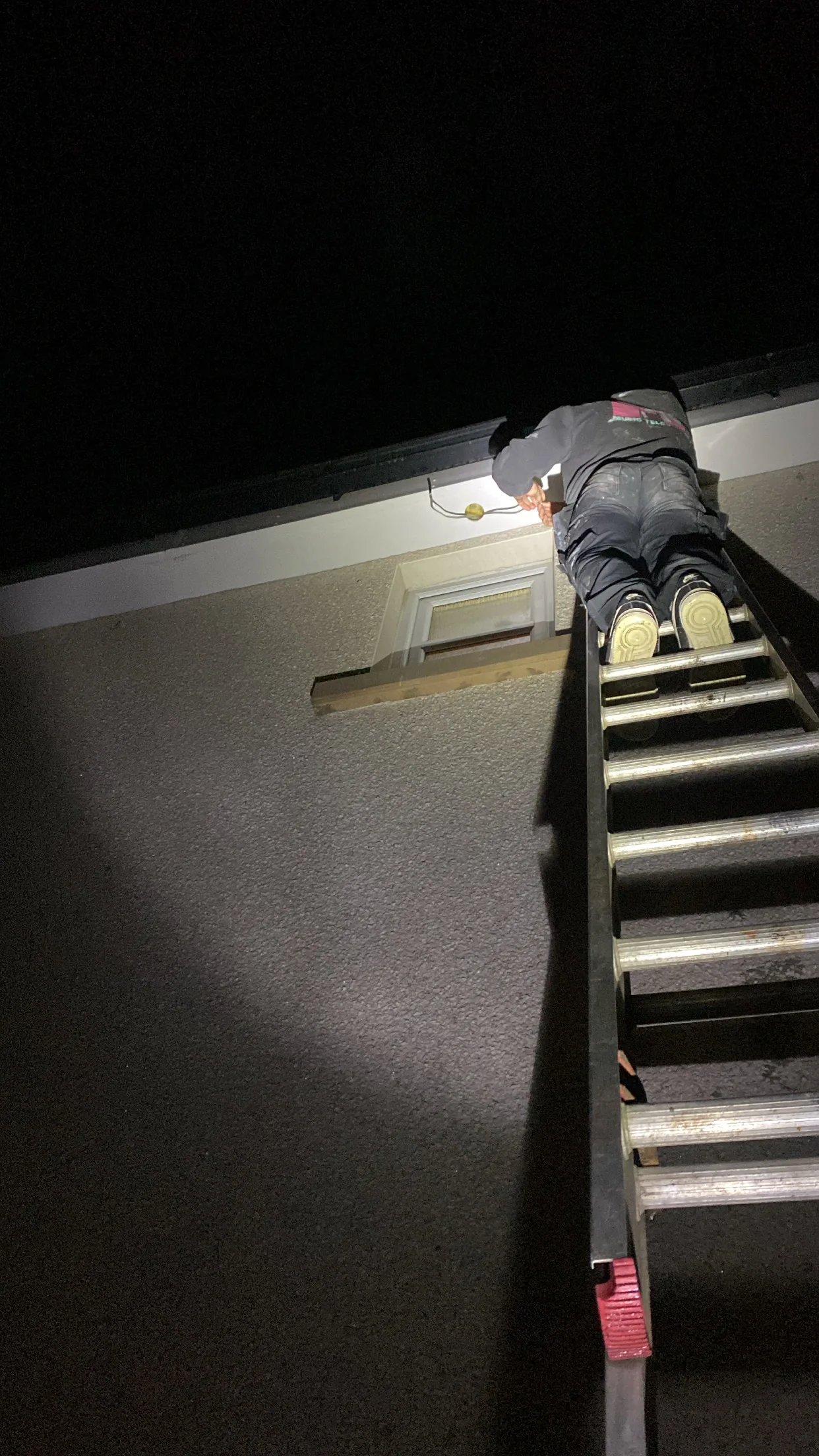MMM Electrical electrician working from a ladder at night repairing an exterior soffit light on a Glasgow house