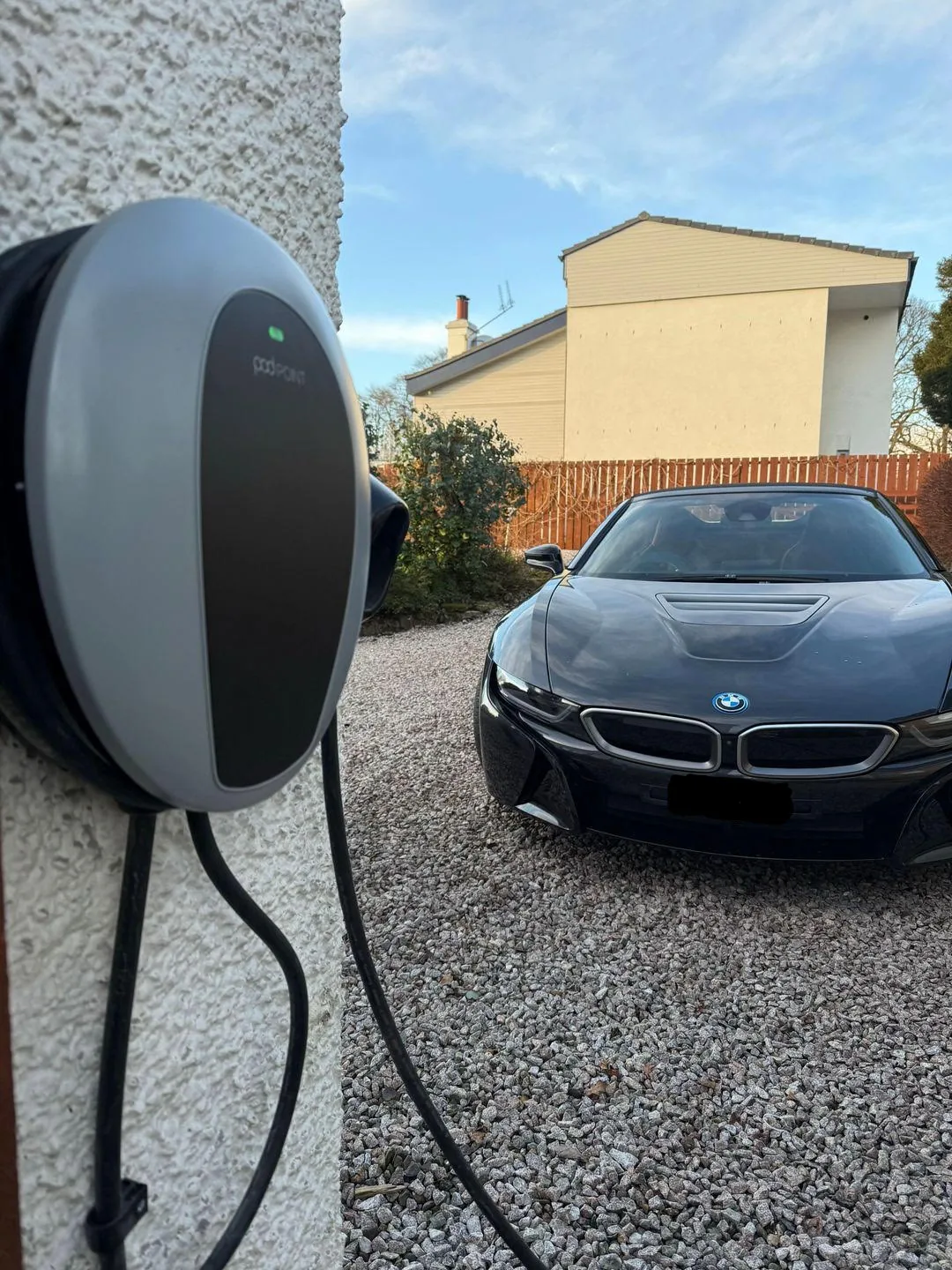 Wall-mounted EV charge point installed by MMM Electrical on a Glasgow driveway, connected and charging an electric car