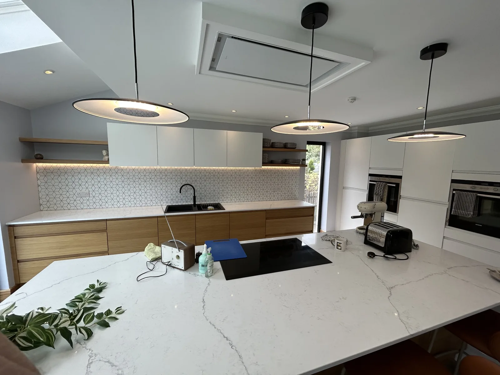 Kitchen island with ceiling pendants and under-cabinet LED lighting installed and wired by MMM Electrical in Glasgow
