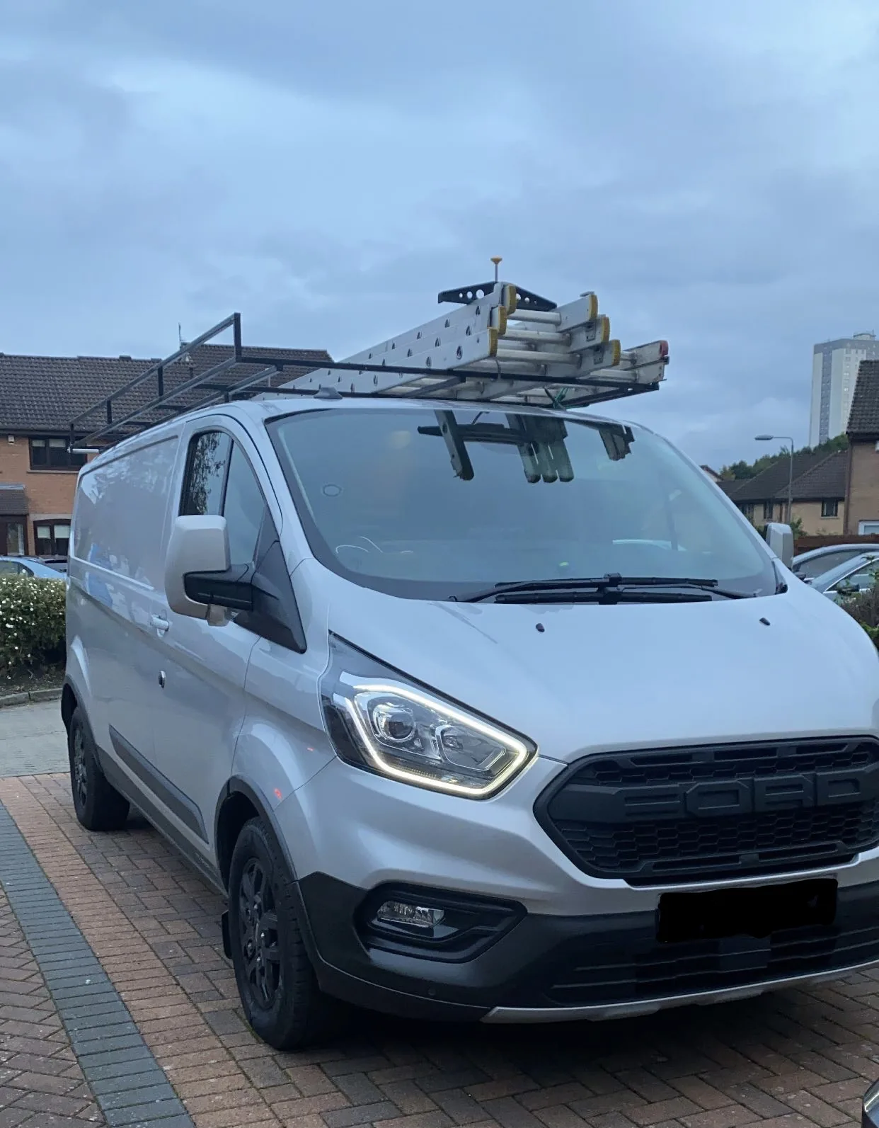 The MMM Electrical van with roof-mounted ladders parked on a residential street
