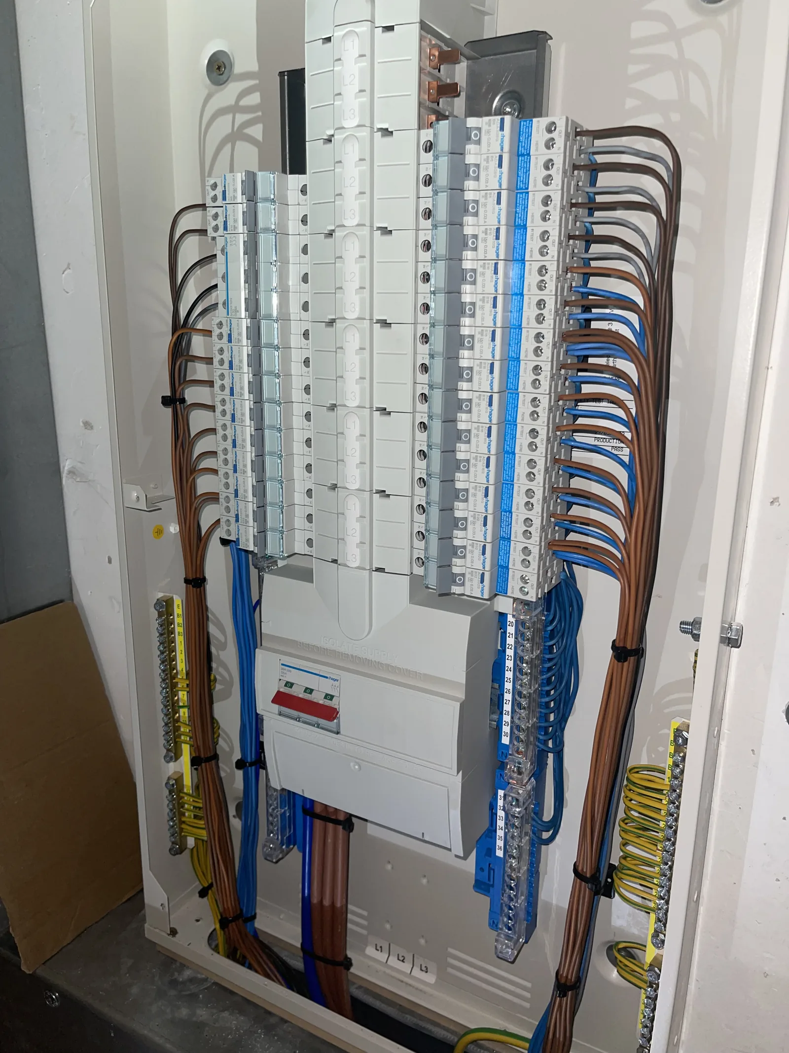 Three-phase distribution board wired and terminated by MMM Electrical, showing neatly dressed conductors across the MCB ways